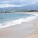 Sea waves breaking on a shore surrounded by verdant mountains